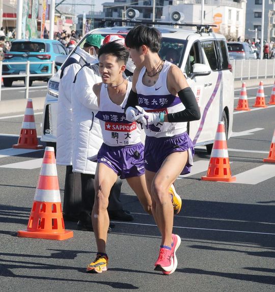 2022年1月2日、平塚中継所で駒大4区の花尾恭輔(右)にたすきをつなぐ3区の安原太陽(代表撮影)