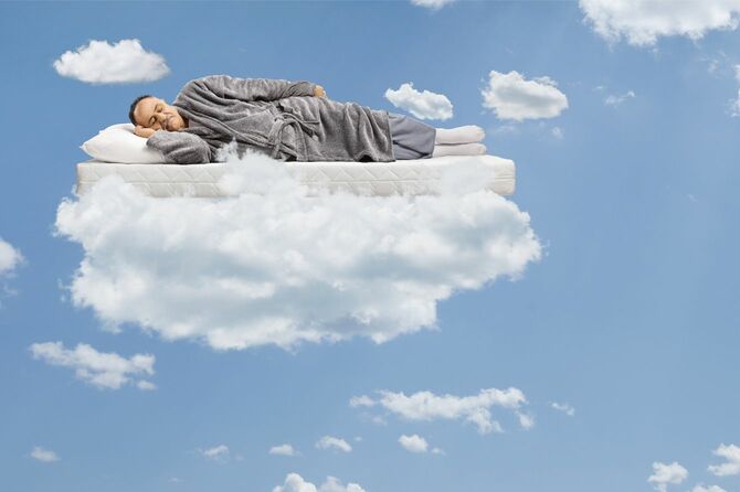 中年男性は、マットの上で眠って、青い空に浮かぶ