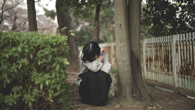 公園の端っこで蹲って泣く女性