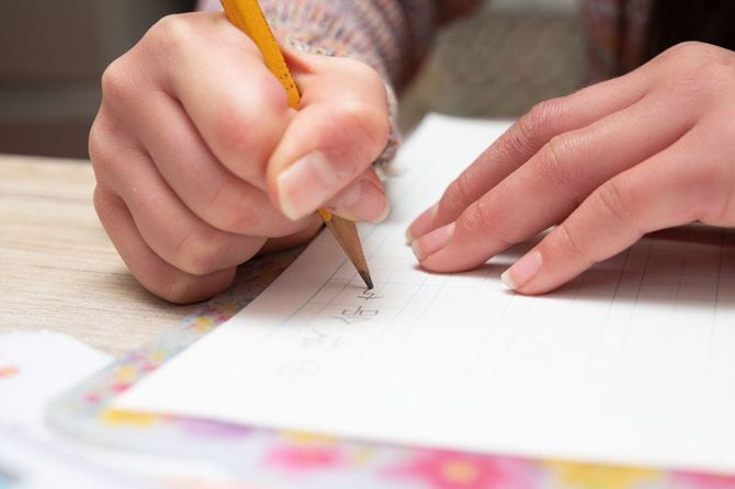 鉛筆で漢字を練習する子供