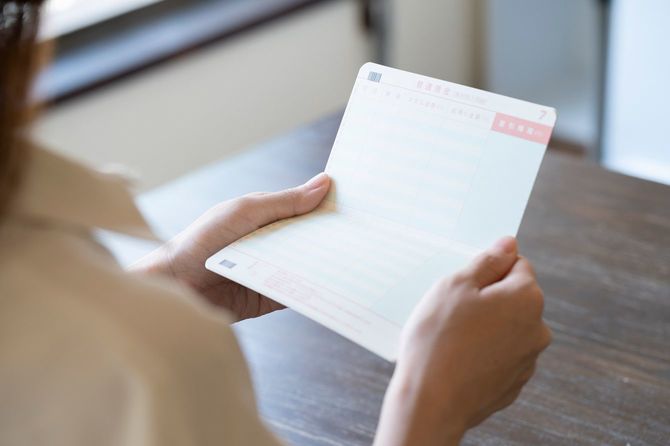 通帳を確認する若い女性の手元