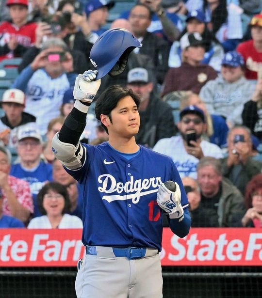 エンゼルスとのオープン戦の1回、ファンの声援にヘルメットを取り応えるドジャースの大谷翔平＝2024年3月26日、アメリカ・アナハイム