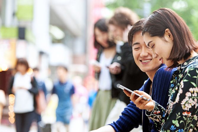 路上で缶ビールを飲む若者