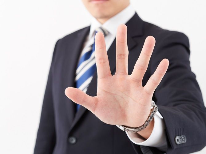 こちらに手のひらを突き出している人