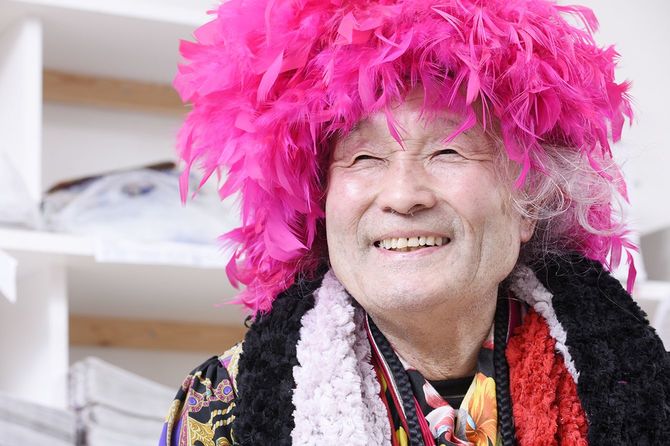 ピンクアフロのカツラで笑う男性