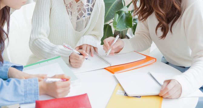 ノートを確認しあう女性達