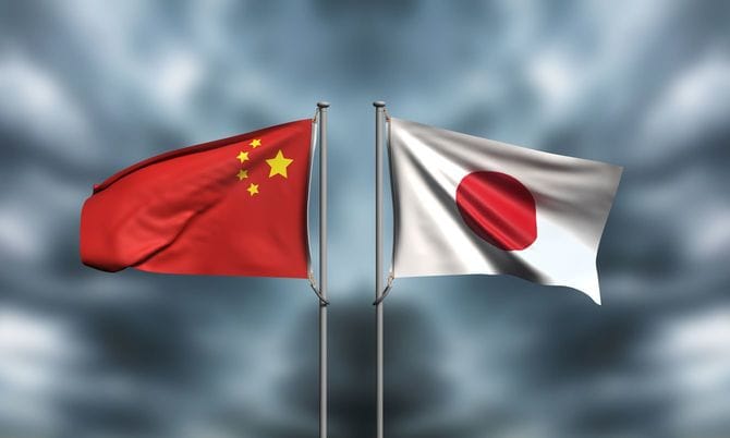 曇天にはためく五星紅旗と日章旗