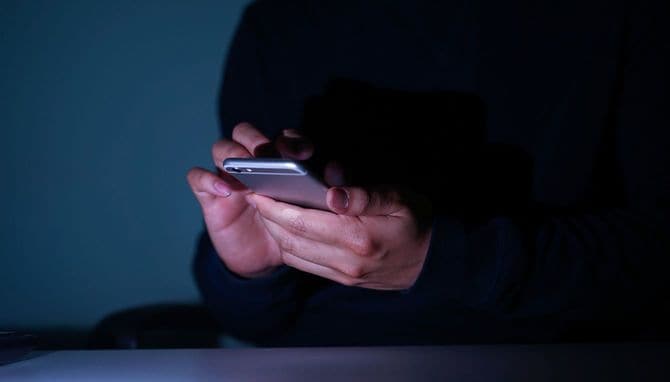 深夜にスマートフォンを操作する人