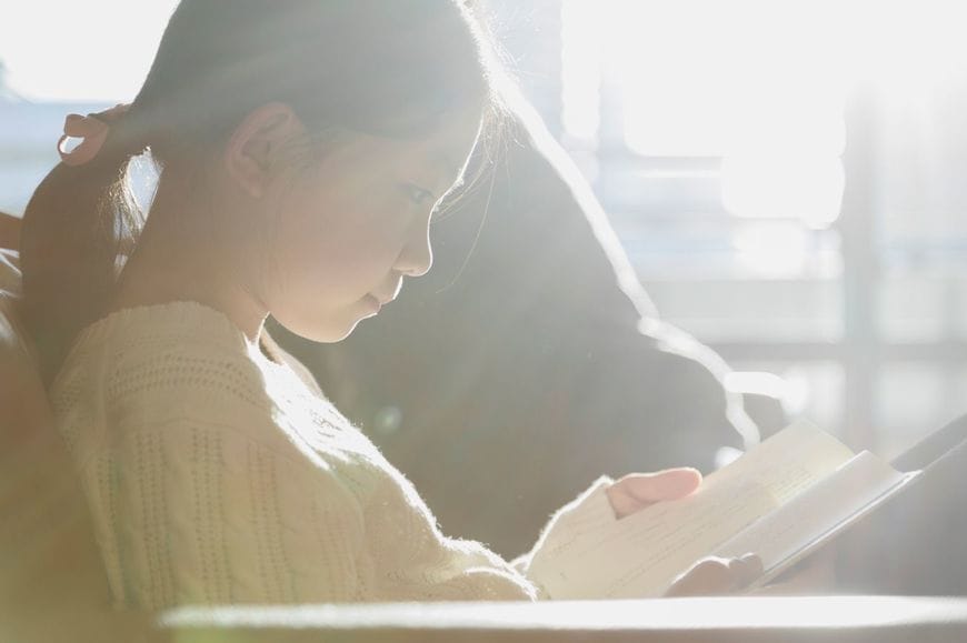 ソファーで本を読んでいる女の子