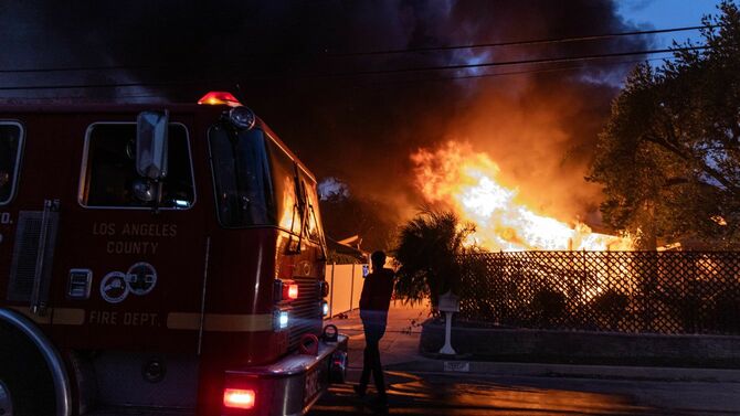 2025年1月8日、燃え上がる炎に照らされるアメリカ・カリフォルニア州アルタデナの住宅街。炎は強風・サンタアナ風によってあおられて広がった。ほとんどの家屋は壊滅的な被害を受けている