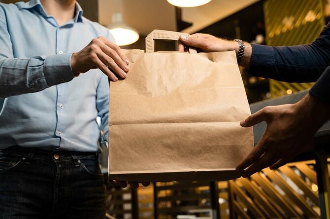 店員から紙袋を受け取る男性