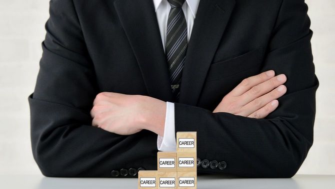 腕を組むビジネスパーソン、キャリアアップのコンセプト