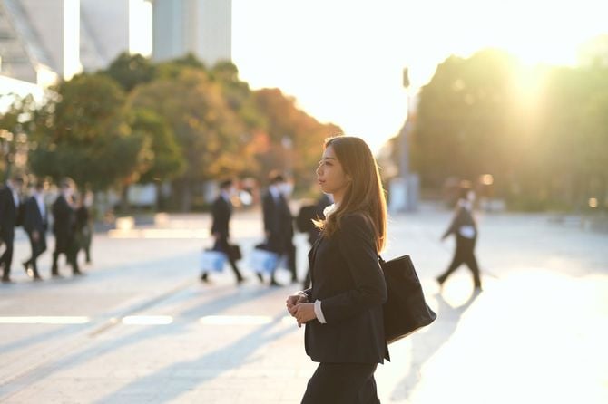 ラッシュアワーを歩くスーツの女性