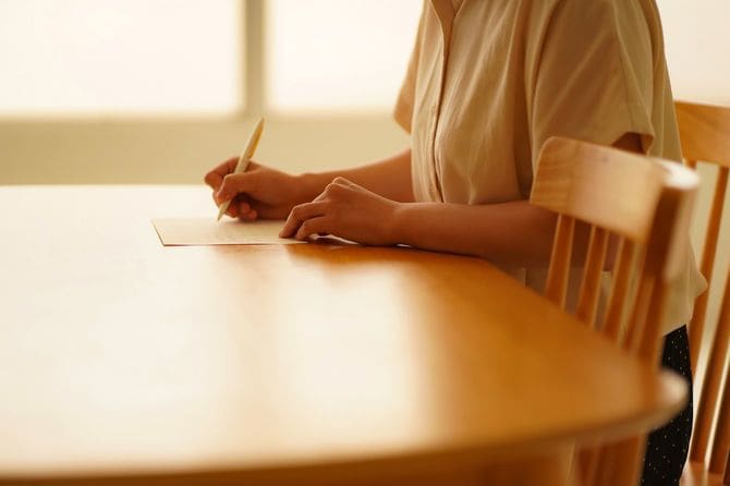 手書きのメモを書く女性