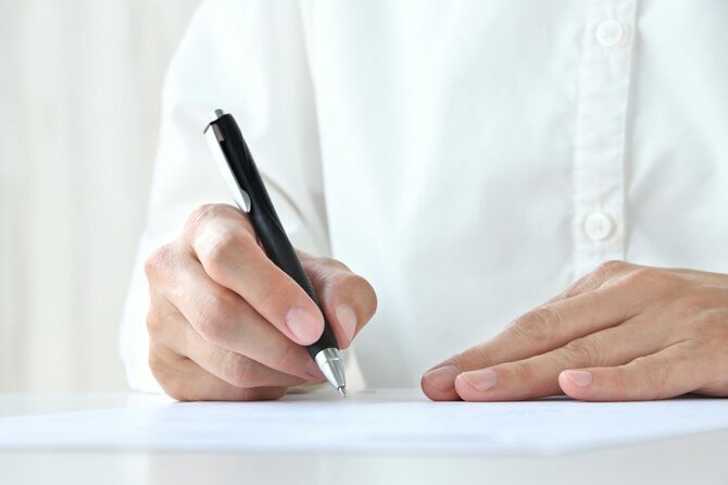 ペンで書き込んでいる手元