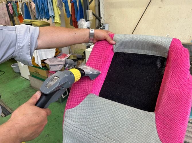 乗務員が専用の洗浄機を使ってシートを清掃する様子