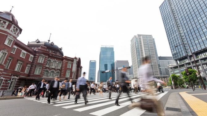 東京駅前の横断歩道を忙しく歩き去る人々
