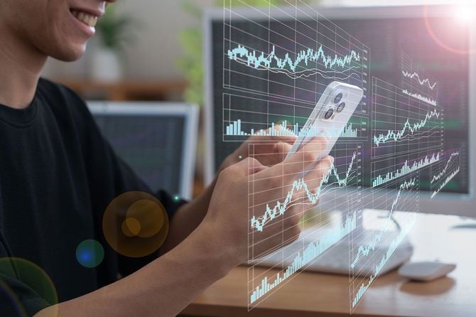 スマホで株価チャートを確認する男性