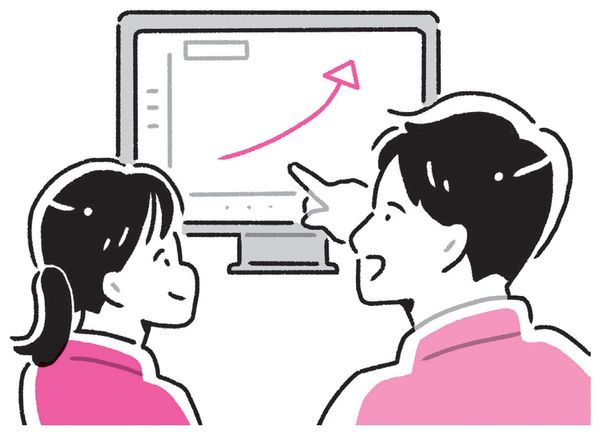 パソコンでグラフを見ている2人の人物