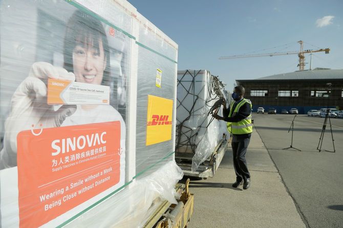 2021年7月8日、ジンバブエのハラレにあるロバート・ムガベ国際空港で、中国からの200万人分の新型コロナウイルスワクチンの一部をコンテナに積み込む準備をする作業員。