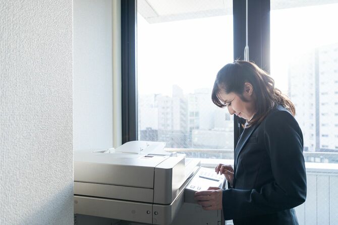 オフィスのコピー機を使用している女性