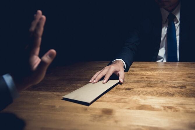 現金の入った封筒を差し出す人とそれを拒否する人