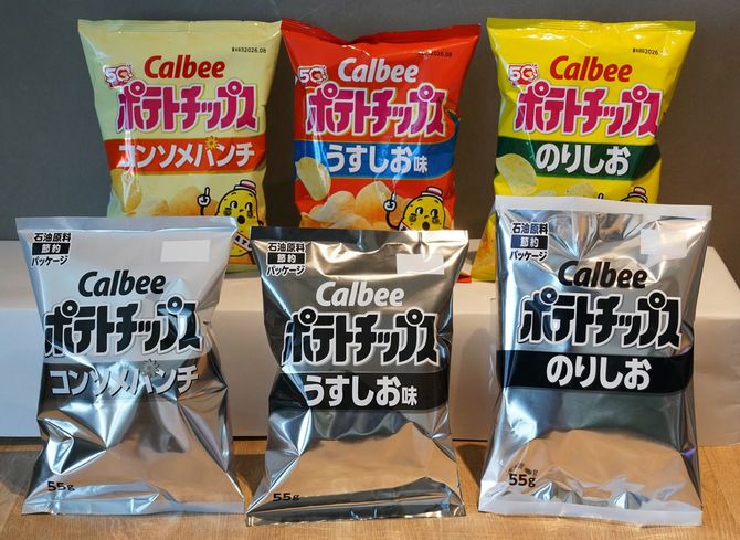 2026年5月14日、東京にあるカルビー本社で、白黒デザインのサンプルパッケージ(下)や現在のオレンジと黄色のパッケージ(上)を含む、カルビーのポテトチップスの袋が展示されている