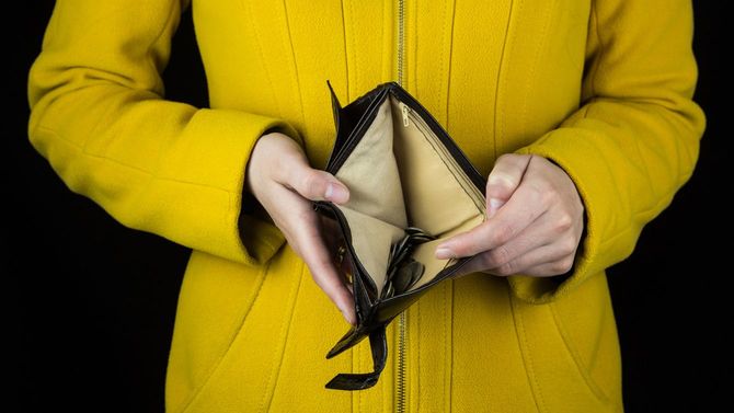 財布を開いて中身を見せている女性