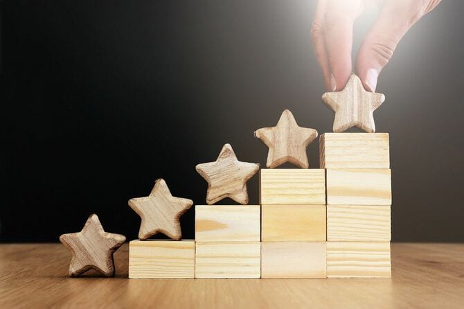 積み木の階段の一番上に星を置く手
