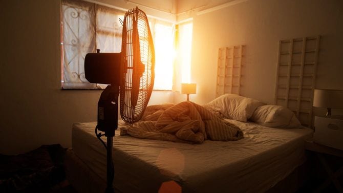 整えられていないベッドの手前に扇風機