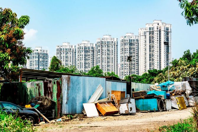 バラックの向こうには高層ビルが立ち並ぶ