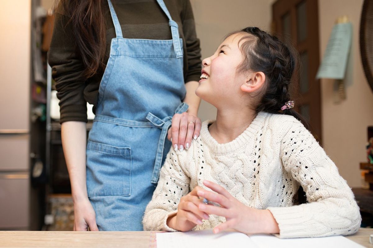 子供の肩に手を置く母親