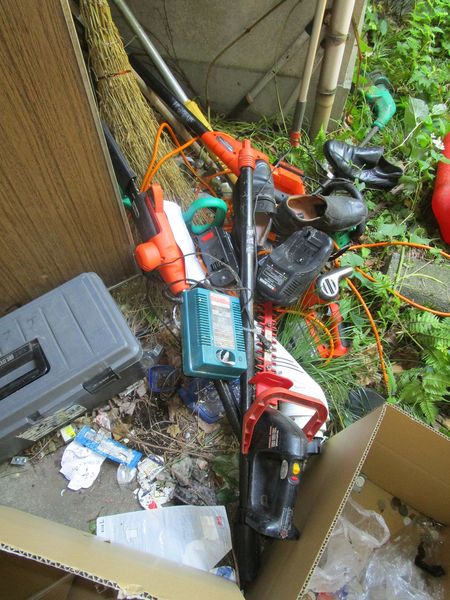 玄関前には20台ほどの草刈り機が放置されていた。