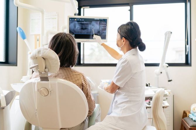 患者にX線について説明する女性歯科医師