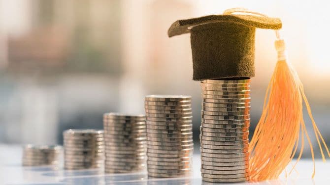 一番高く積み上げられたコインに学位帽がかぶせられている