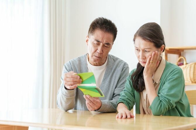 通帳を見ている夫婦