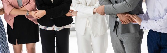 手を繋ぐスーツを着たビジネスパーソンの人々