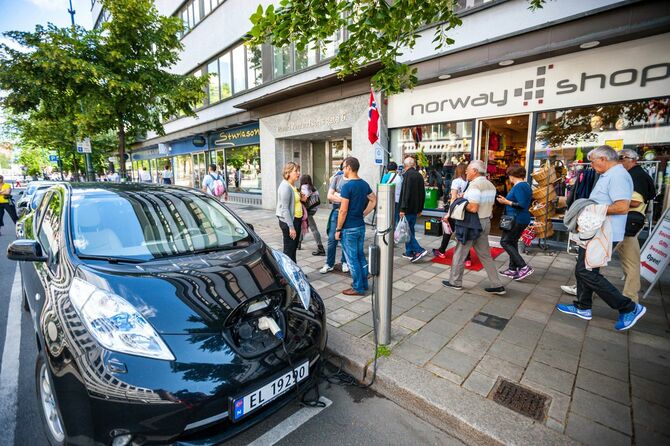2015年6月20日、ノルウェー・オスロ。ギフトショップ前の路上には、充電中の電気自動車