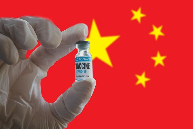 COVID-19ワクチンボトルと中国国旗の背景
