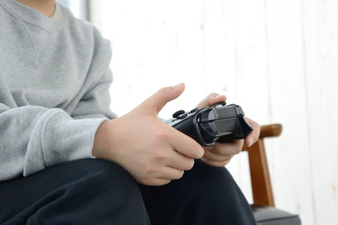 リビングルームでビデオゲームを楽しむ子供の手