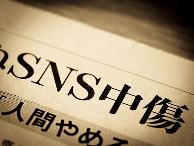 「SNS中傷」と書かれたニュースの見出し