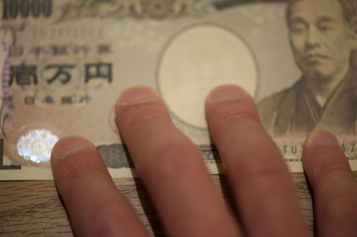一万円札を手にする人のイメージ