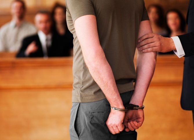 手錠をされ、法廷に立つ男性