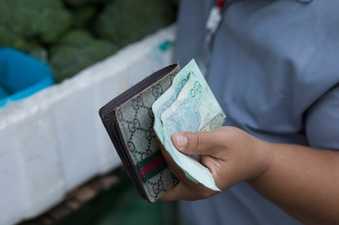 財布と紙幣を持つ東南アジア人の手元