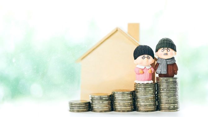 積み上げたコインの上にいるシニアカップル