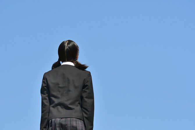 一人で空を見上げる女子学生