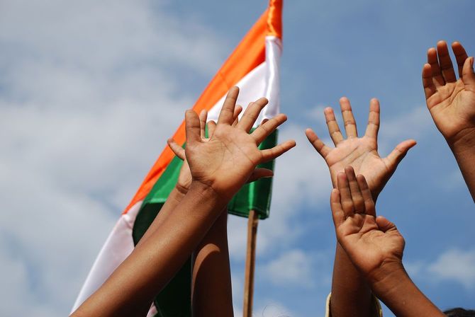 インドの国旗と掲げた人々の手
