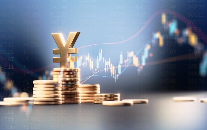 青い財務グラフの前にコインスタックの上に円記号