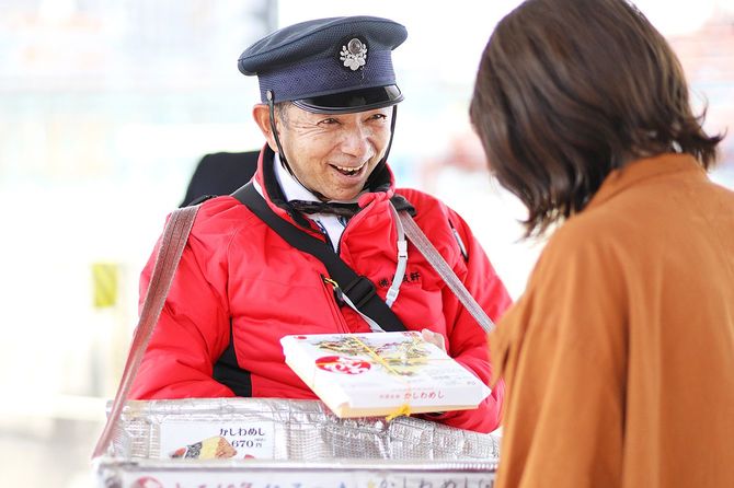 駅弁当を立ち売りする男性と客