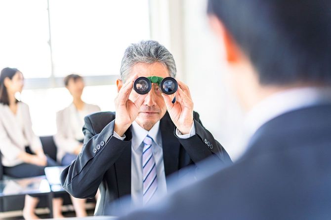 双眼鏡で部下を観察する人